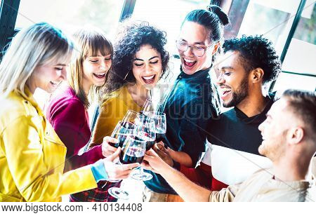 Young Multiracial People Drinking And Toasting Red Wine At Dinner Party - Happy Drunk Friends Having