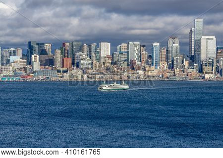 A Ferry Moves Across Elliott Bay In Front Of Skyscrapers In Seattle, Washington.