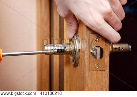 Door Installation, Worker Installs Door Knob, Woodworker Hands Close Up. A Man Spins The Door Handle