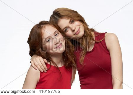 Cheerful Mom And Daughter Next To Red Dresses Hugs Lifestyle Light Background Smile