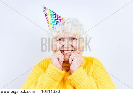 Older Woman Wear Yellow Sweater And Horn Cap On A White Background