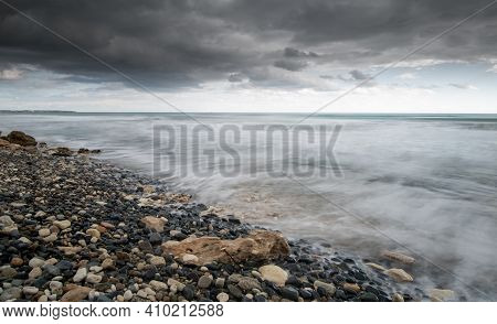 Seawaves Splashing To The Coast With Pebbles Against Stormy Dramatic Cloudy Sky. Wintertime, Longexp