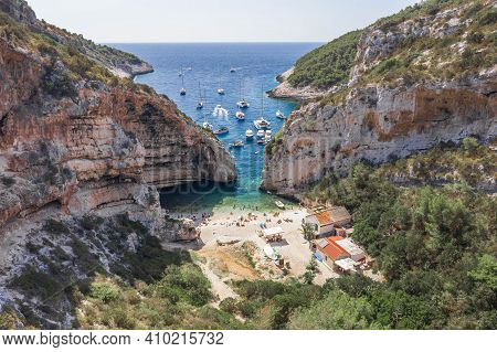 Aerial View Of Tourists Sunbath Swim At Stiniva Cove Beach Of Adriatic Sea On Vis Island In Croatia 