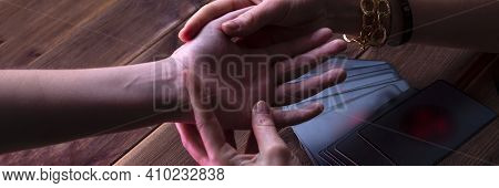 Minsk, Belarus, December 27, 2019. Fortune-teller's Hands With Predictions On A Wooden Background. F