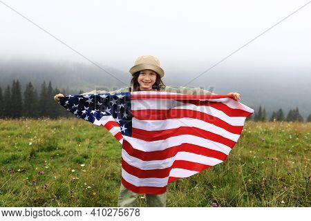 Happy Adorable Little Girl Smiling And Waving American Flag. Patriotic Holiday. Happy Kid, Cute Litt
