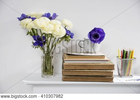 One Blue Anemone In A Cup In The Style Of The Seventies On The Table With Books As An Interior Decor