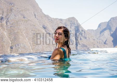 Beautiful Woman In A Blue Swimsuit In The Water In Front Of A Huge Mountains In A Grotto In Tolanton