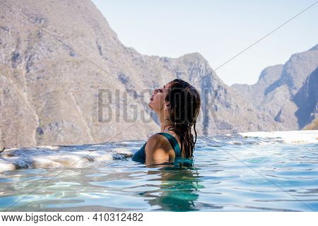 Beautiful Woman In A Blue Swimsuit In The Water In Front Of A Huge Mountains In A Grotto In Tolanton