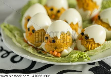 Appetizer Of Boiled Stuffed Decorative Eggs In The Form Of Small Chicks Placed On Lettuce. Easter De