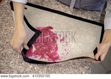 Closeup Female Hands Crushing Dyed Pink Isomalt Caramel For Cake Decor On Confectionery Mat