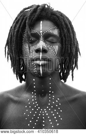 A black and white portrait of a man with apinted face and chest 