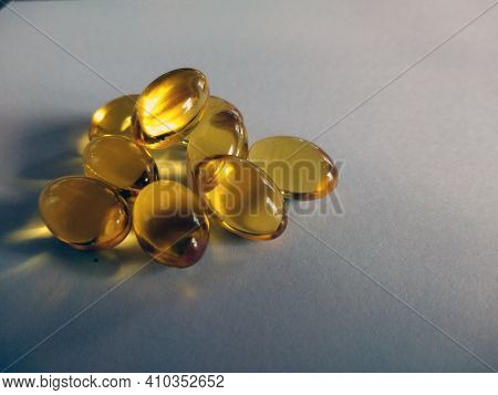 Herbal Oil, Cold Pressed Vitamin Capsule, Body Care Drug. Yellow Shiny Oil Health Supplement