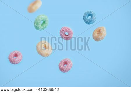 Close Up Colorful Loops Of Fruit Grains In Flight On A Blue Background. Colorful Breakfast Food