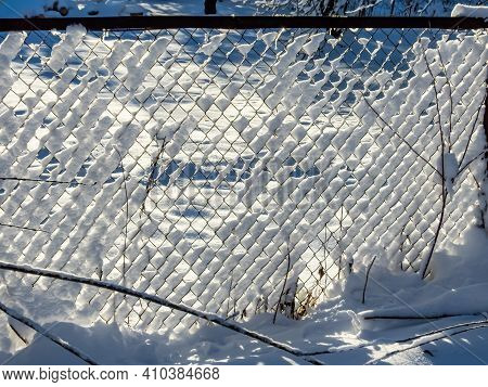 Metal Fence Covered With Piles Of Snow After Snowfall In Winter