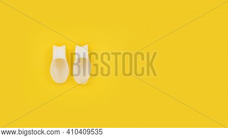 White Silicone Finger Divider On A Yellow Background. Prevention And Treatment Of Hallux Valgus