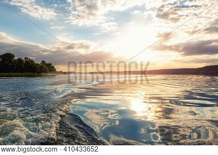Scenic Bright Vibrant Blue To Red Warm Sunset Evening Time Landscape With Motorboat Swirl Trace On W