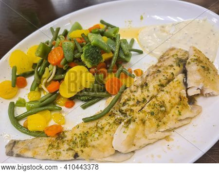 To Portions Of Fresh Grilled Pollock Or Coalfish Served With Colorful Salad And Slices Of Lemon, Clo