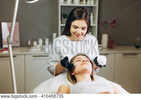 Cosmetologist Applying Cream Essence Essential Vitamins Into Face To Improve Client Skin. Beauty Exp