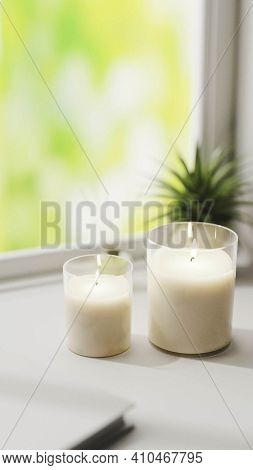 Scented Candle, Burning White Aromatic Candles In Glass On White Surface With Green Plant On Backgro