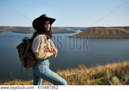 Pretty Female Tourist In Cowboy Hat Hiking With Backpack At National Park Podillya Tovtry. Happy Wom