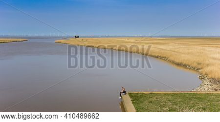 Oldambt, Netherlands - April 11, 2020: Young Couple Relaxing At The Dollard Bay In Groningen, Hollan