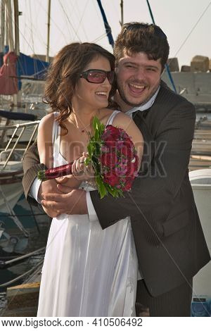  The beautiful, happy groom and the bride on prewedding walk in ancient to port.   