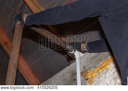 A Man Is Installing An Iron Pipe For A Solid Fuel Heating Boiler In A Private Country House.