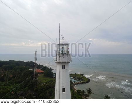 Aerial View Of Lighthouse Sea Rock Sunset Landscape. Sunset Lighthouse Scene. At Anyer Beach With No