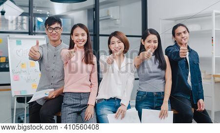 Group Of Asia Young Creative People In Smart Casual Wear Smiling And Thumbs Up In Creative Office Wo