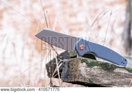 Knife With A Tanto Blade. Knife On The Background Of Hay At The Edge Of The Log. Photo Of A Knife In