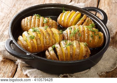 Rustic Style Sliced And Baked Hasselback Potatoes Close-up On A Frying Pan On The Table. Horizontal