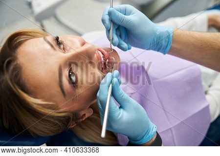 Dental Mirror And Explorer In A Female Mouth