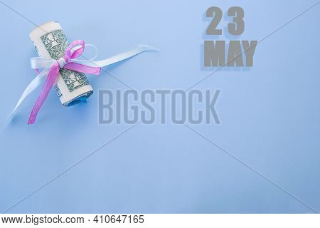 Calendar Date On Blue Background With Rolled Up Dollar Bills Pinned By Blue And Pink Ribbon With Cop