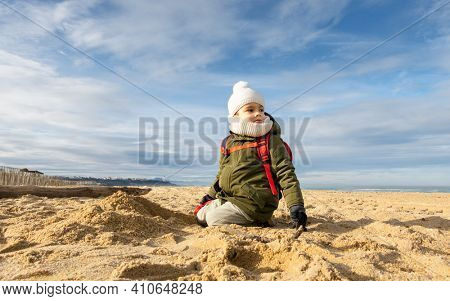 Little boy looking away on beach, beautiful winter season
