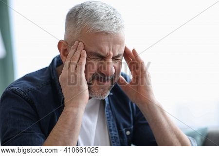 Closeup Of Mature Grey-haired Man Suffering From Headache At Home, Touching His Temples, Panorama Wi