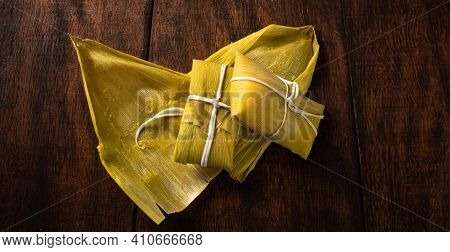 Pamonha, Brazilian Corn Food, Called Pamonha. On A Rustic Table With Knife, Low Key Portrait, Dark A
