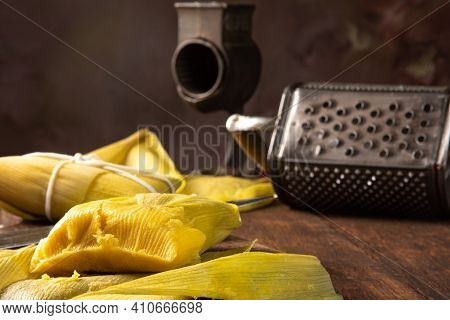 Pamonha, Brazilian Corn Food, Called Pamonha. On A Rustic Table With Knife And Old Corn Grater, Low