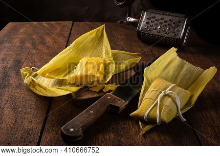 Pamonha, Brazilian Corn Food, Called Pamonha. On A Rustic Table With Knife And Old Corn Grater, Low