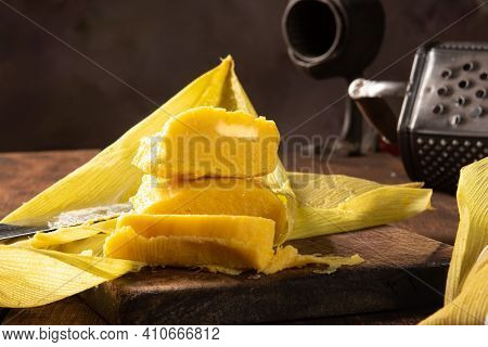 Pamonha, Brazilian Corn Food, Called Pamonha. On A Rustic Table With Knife And Old Corn Grater, Low