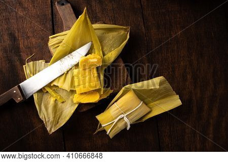 Pamonha, Brazilian Corn Food, Called Pamonha. On A Rustic Table With Knife, Low Key Portrait, Dark A