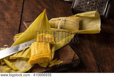 Pamonha, Brazilian Corn Food, Called Pamonha. On A Rustic Table With Knife And Old Corn Grater, Low