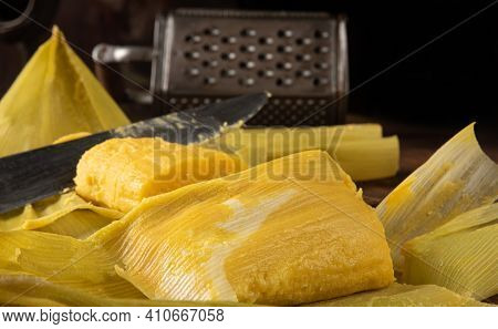 Pamonha, Brazilian Corn Food, Called Pamonha. On A Rustic Table With Knife And Old Corn Grater, Low