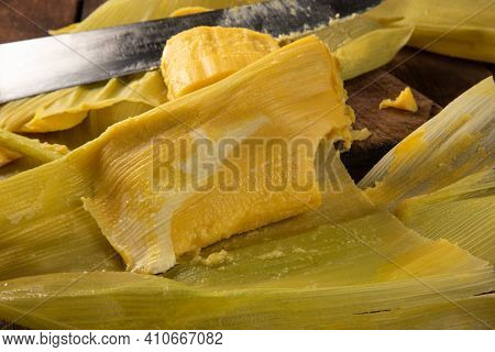 Pamonha, Brazilian Corn Food, Called Pamonha. On A Rustic Table With Knife And Old Corn Grater, Low