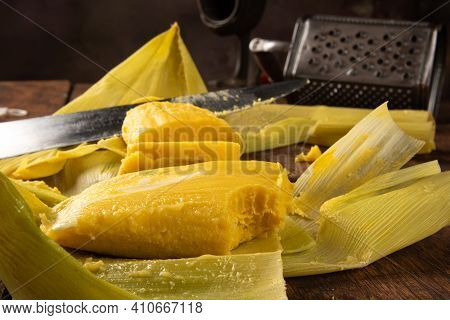 Pamonha, Brazilian Corn Food, Called Pamonha. On A Rustic Table With Knife And Old Corn Grater, Low