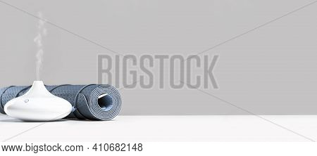Rolled Blue Yoga Mat And Essential Oil Diffusor For Enhanced Practice. Ultrasonic And Humidifying Ar
