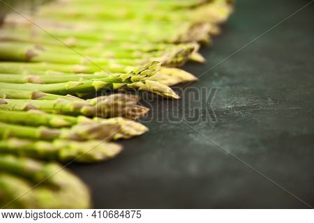Bunch Of Asparagus Arranged In A Row On Dark Grey And White Background With Copy Space. Green Aspara