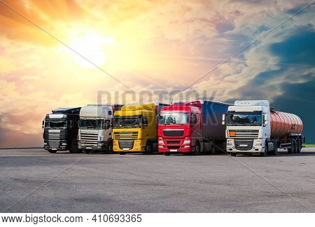Semi-trailers Truks In A Row In The Parking Lot Against The Sky