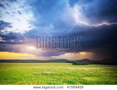 Prato in montagna. Nube di pioggia e fulmini. Composizione di natura.