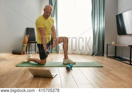 50 Year Old Trainer Showing How To Correctly Perform The Exercising With A Dumbbell. Athletic Man At