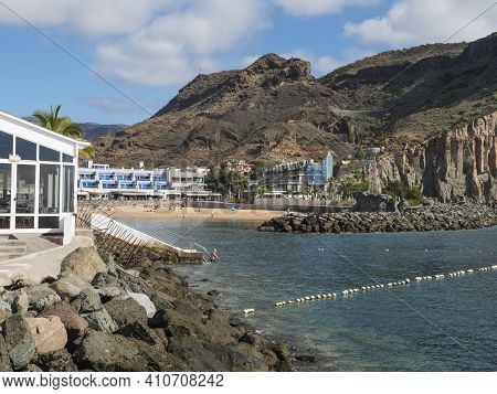 Puerto De Mogan, Gran Canaria, Canary Islands, Spain December 18, 2020: View On The Public Beach Wit